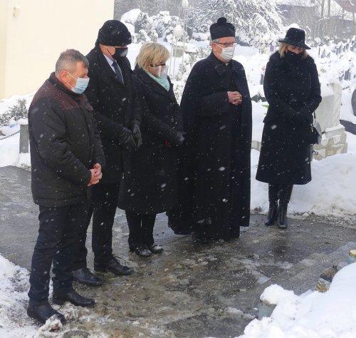 Zdjęcie przedstawia osoby składające kwiaty na mogile ofiar Marszu śmierci